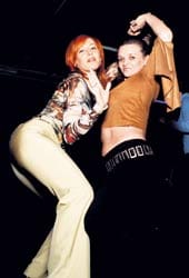 Olga ja Lena viihtyvät tanssilattialla. Walter pitelee käsilaukkua.