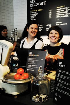 Etualalla sisarukset Anu Syrmä ja Kaisa Leikola, taustalla Aleksi Perälän suunnittelema uusi Sis.Deli + Café.