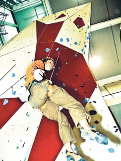 Kiipeilyvision yksi omistajista Joonas Sailaranta kiipeilyseinällä. Seinän kiipeilyreittejä muutetaan säännöllisesti.