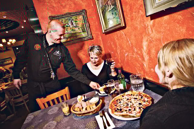 Vuoropäällikkö Juha  Piispanen tarjoilee Manalassa Eija Joensuulle etanoita ja Minna Luomalle pitsaa.