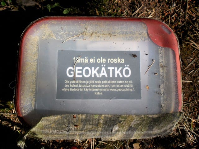 Esimerkki kätköpurkista: vesitiivis rasia tyypillisellä kätkötiedotteella: ei roska, vaan geokätkö.