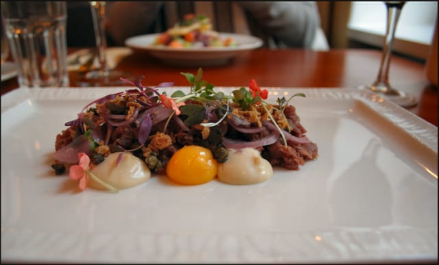 Härkätartar - Dijonmajoneesia, keltuaista ja rapeaa sipulia. / Toisena alkupalana taustalla Västerbotten-juustosalaattia.