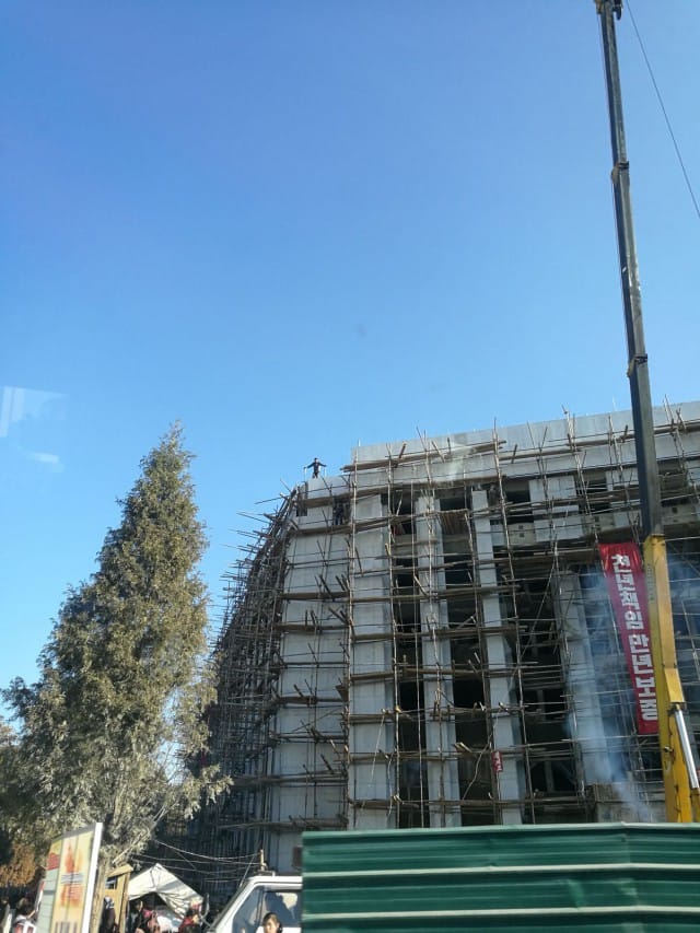 Nyt on käynnissä 200 päivän kampanja. Siloin kaikki tsemppaavat ja tsemppauskuoro käy työmaiden edessä soittamassa. Rakennukset valetaan paikallaan. Rakennustelineet rakennetaan käsin, laudoista.