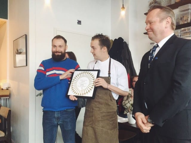 Lauri Kähkönen ja Toni Kostian vastaanottavat Vuoden Ravintola -kunniakirjan Kim Palhusilta.