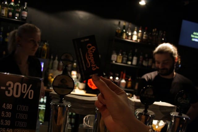 Pöpsyt käsiojossa tilaamassa kuplivaa cocista!