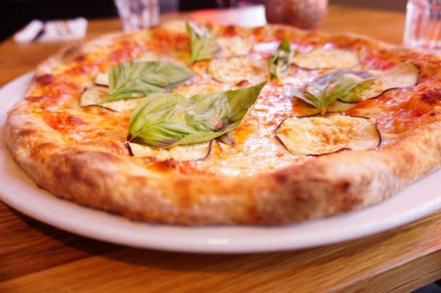 Pjazzan pizza parmigianassa on munakoisoa, tomaattia, mozzarellaa, basilikaa ja grana-juustoa.