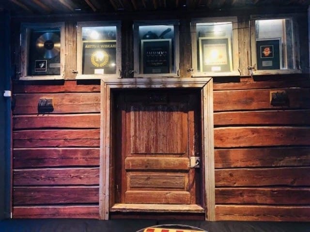 Seinälle on ripustettu Arttu Wiskarin kulta- ja platinalevyjä.