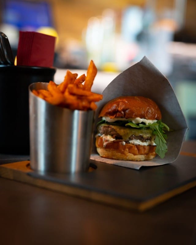 Deluxe Burger & Pizzan Tony's burger: Briossisämpylän välissä grillattua punasipulia, pekonihilloa, Monterey Jack -juustoa, laavakivillä grillattu Black Angus -pihvi, valkosipulimajoneesia ja rucolaa.