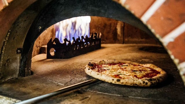 Aito puu-uuni on yksi Via Tribunalin pizzojen maun salaisuuksista.