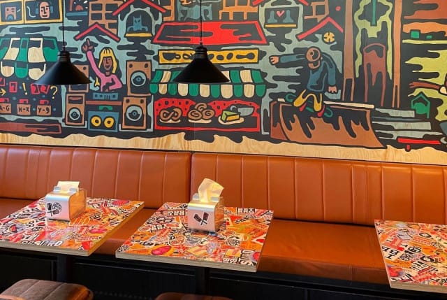 Graffitit ja pöytiin liimatut tarrat kuuluvat oleellisena osana Bastard Burgersin sisustusta.