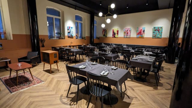 Vaihtuva taidenäyttely ravintolasalissa.