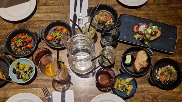 Sävelen uudistetut tapakset. Oliiveja, marinoitua parsaa, lohipastramia, karamellisoitua häränkieltä, savumuikkua, talon leipää valkosipulivoilla, bruschettaa.