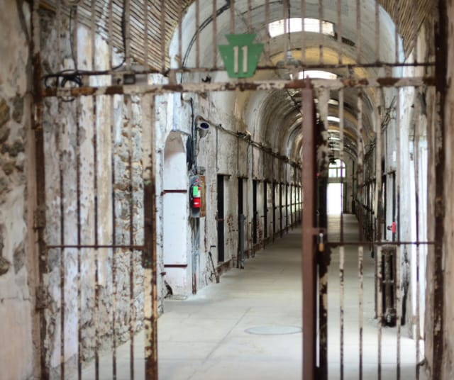 Eastern State Penitentiaryn käytävä, jossa on ruostuneet kalterit ja sähköiset lukot. 