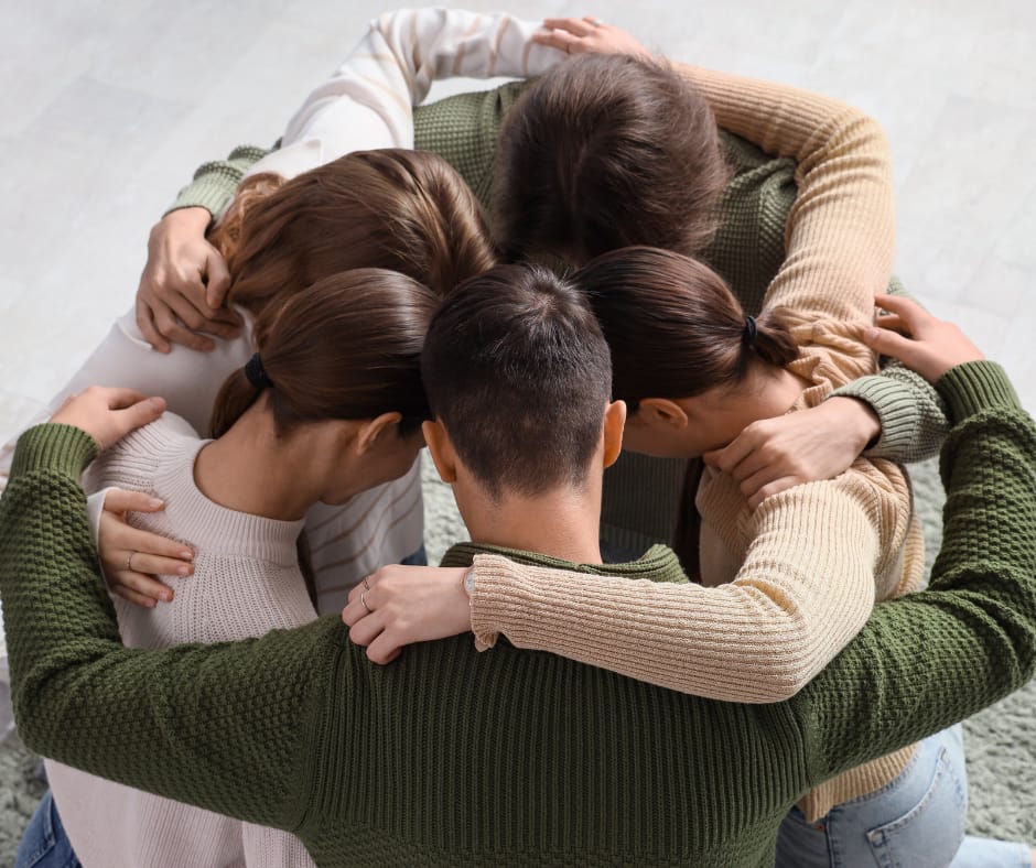 Kuvassa viisi sisarusta on ringissä ryhmähalissa. Sisarukset näkyvät ylhäältäpäin.