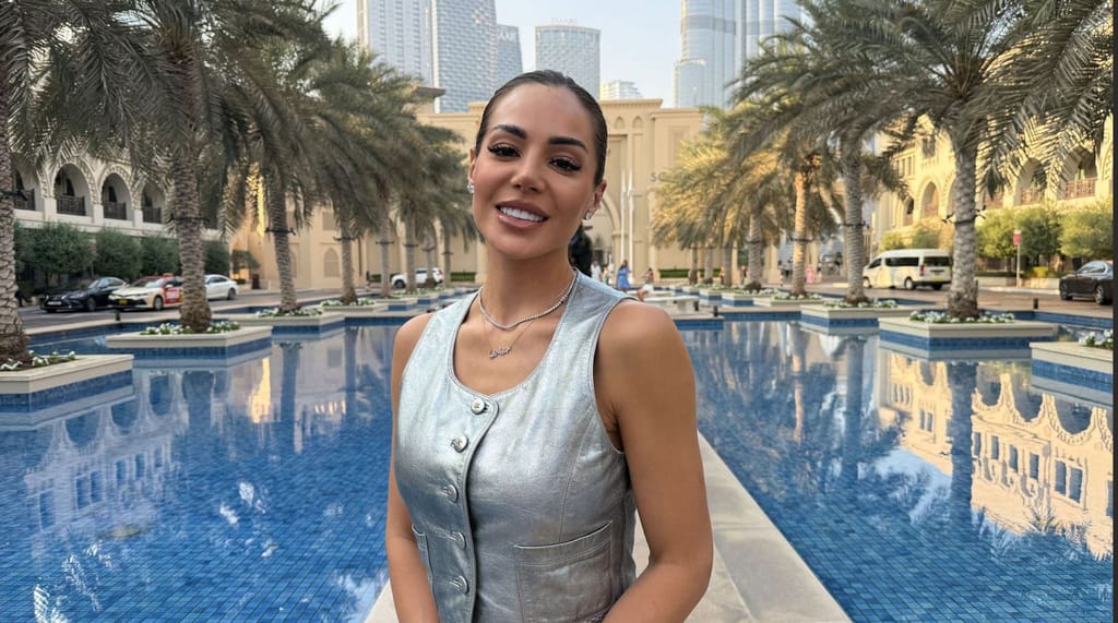 Sofia Belórf hopeisessa liivissä Dubaissa, taustalla palmuja, allas ja Burj Khalifa -pilvenpiirtäjä.