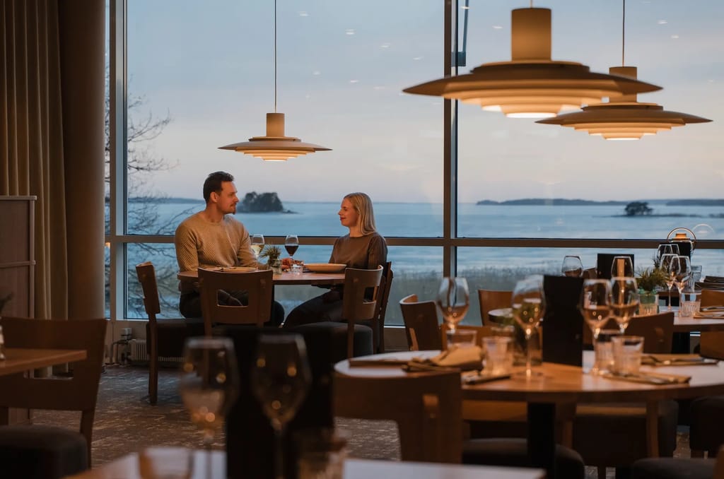 Restaurant Aavan ravintolasali, jossa kaksi ihmistä pöydässä.