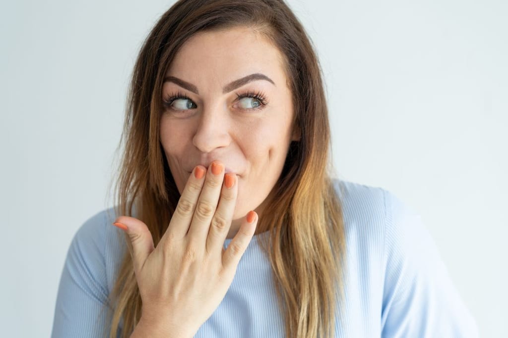 Nainen näyttää huvittuneesti "hups" elettä. Kuvituskuva rahankäyttöartikkeliin. 