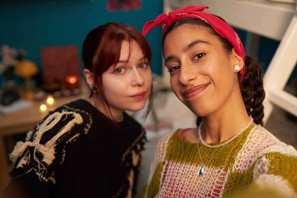 Gen Z edustajat yhteiskuvassa. Molemmilla on rennot villapaidat päällä ja lävistyksiä. Artikkelikuva Gen Z:tä käsittelevässä jutussa. Toisella tytöistä on bridge-lävistys, toisella kaulakoru. 