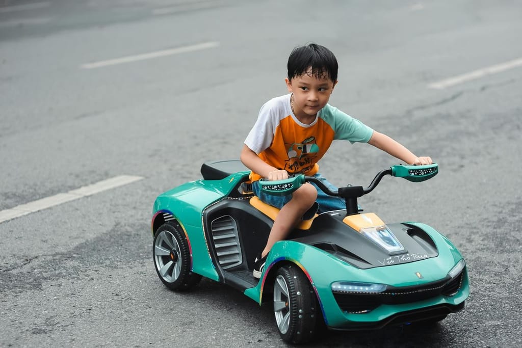 lapsi sähkökäyttöisellä kalliilla polkuautolla 