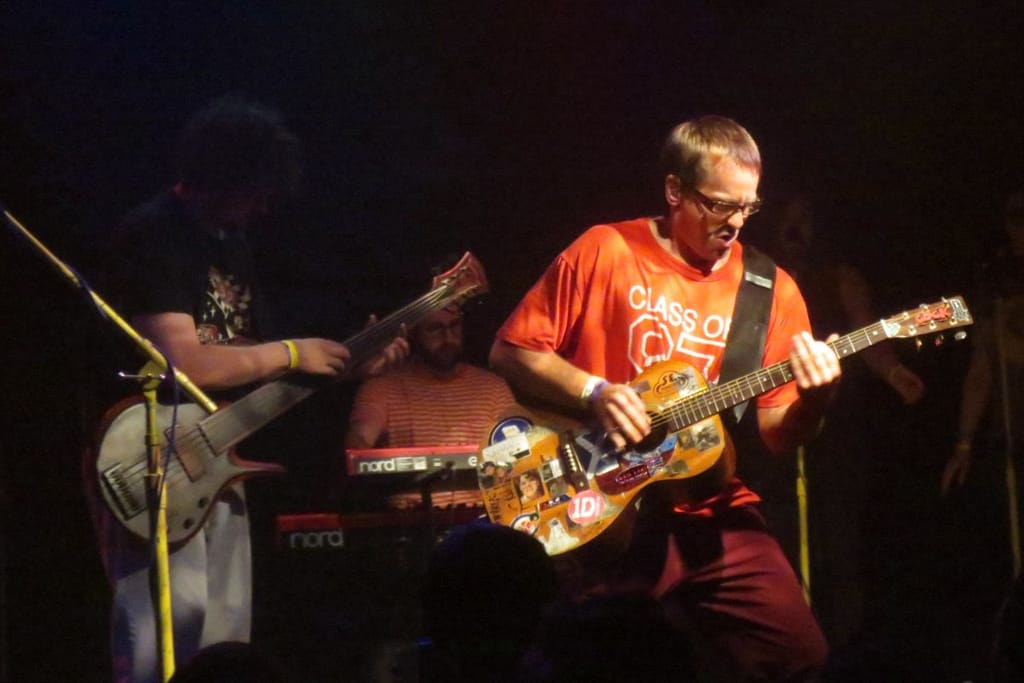 Whaetus yhtye keikalla jossain. Otettu kuva lavalta jossa punapaitainen mies soittaa kitaraa