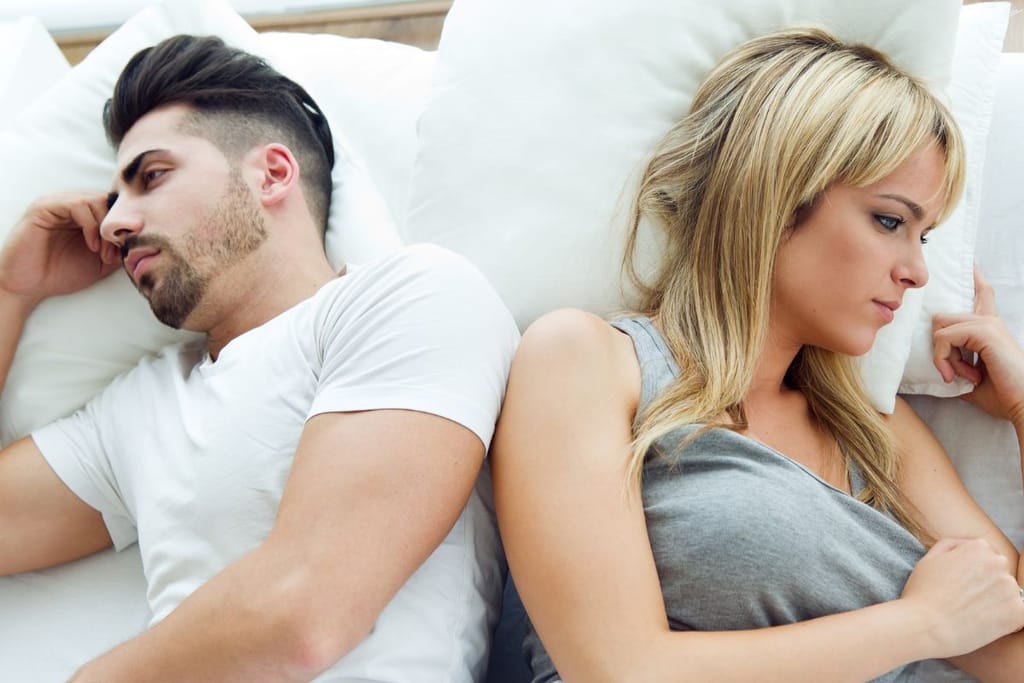 Nainen ja mies selät vastakkain sängyllä omissa ajatuksissaan. Selkeästi kumpaakin vaivaa jokin, eikä heillä näytä menevän hyvin. Kuvituskuva, joka sopisi myös Ikean katalogiehin. 