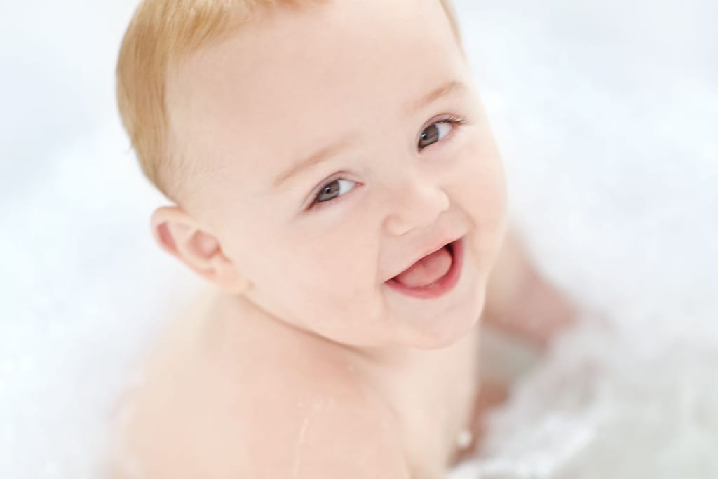 Vauva hymyilee kuvassa ilmeisesti kylvyssä. 