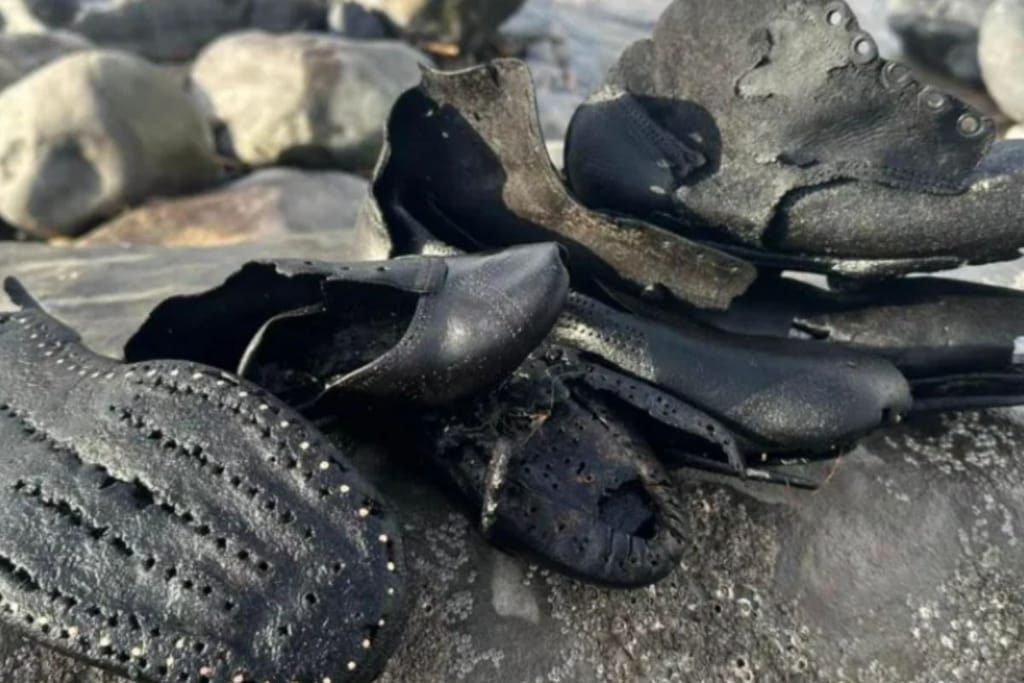Viktoriaanisen ajan nahkakenkiä pinossa, jotka ovat huuhtoutuneet rantaan.
