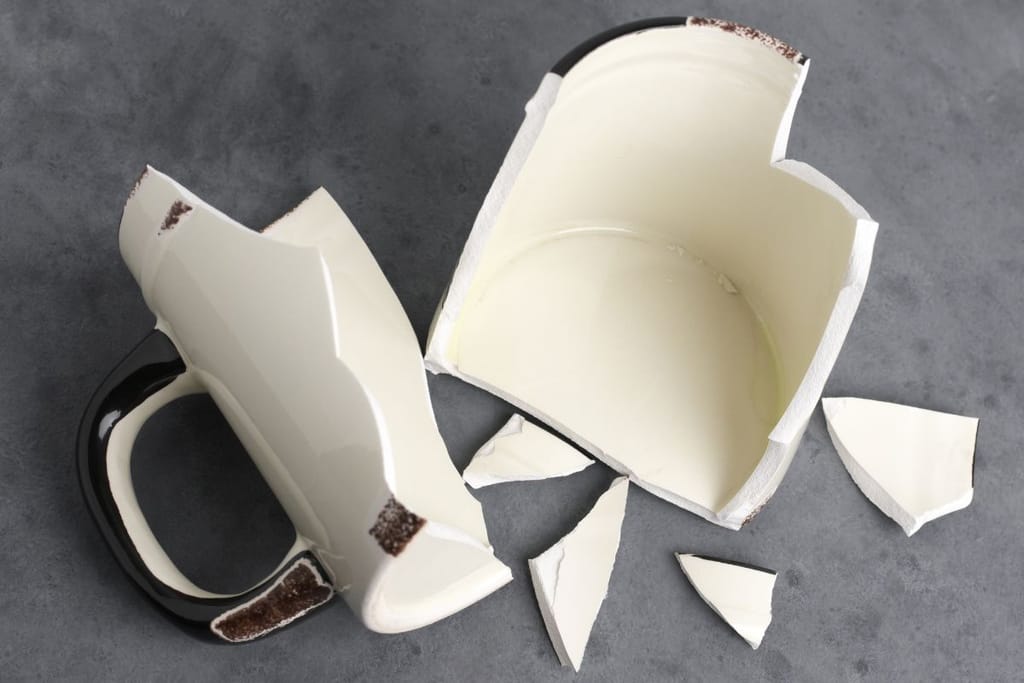 Rikkinäinen kahvikuppi, jossa on musta kahva. Kuvituskuva artikkeliin huijauksista. 