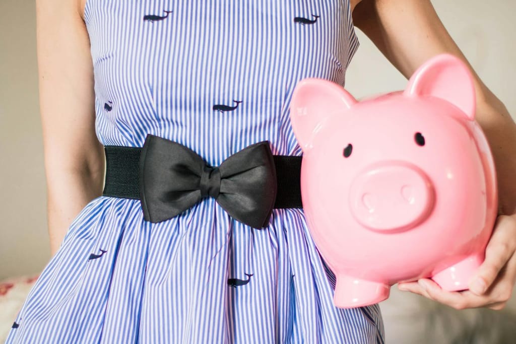 Nainen seisoo säästöpossu kainalossa. 