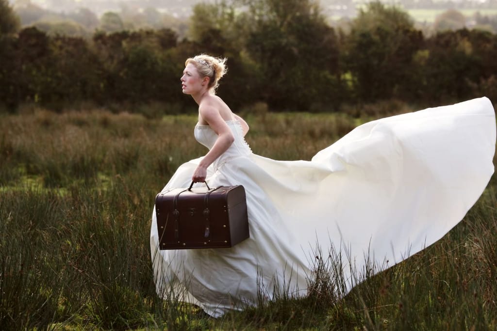 Morsian juoksee pellolla matkalaukku kainalossaan ja näyttää olevan pakomatkalla. 