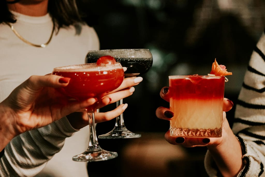 Erilaisia drinkkejä ja cocktaileja pidetään käsissä.