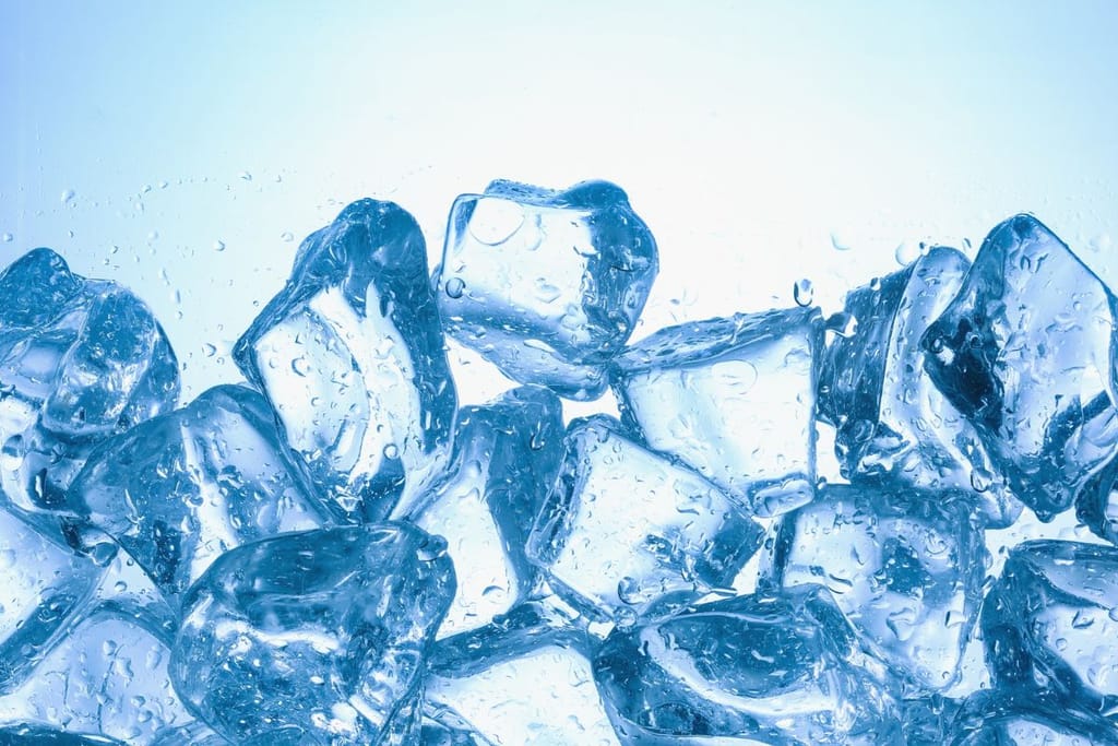 Jääpaloja sinertävällä taustalla, veden pisaroita jääpalojen pinnalla