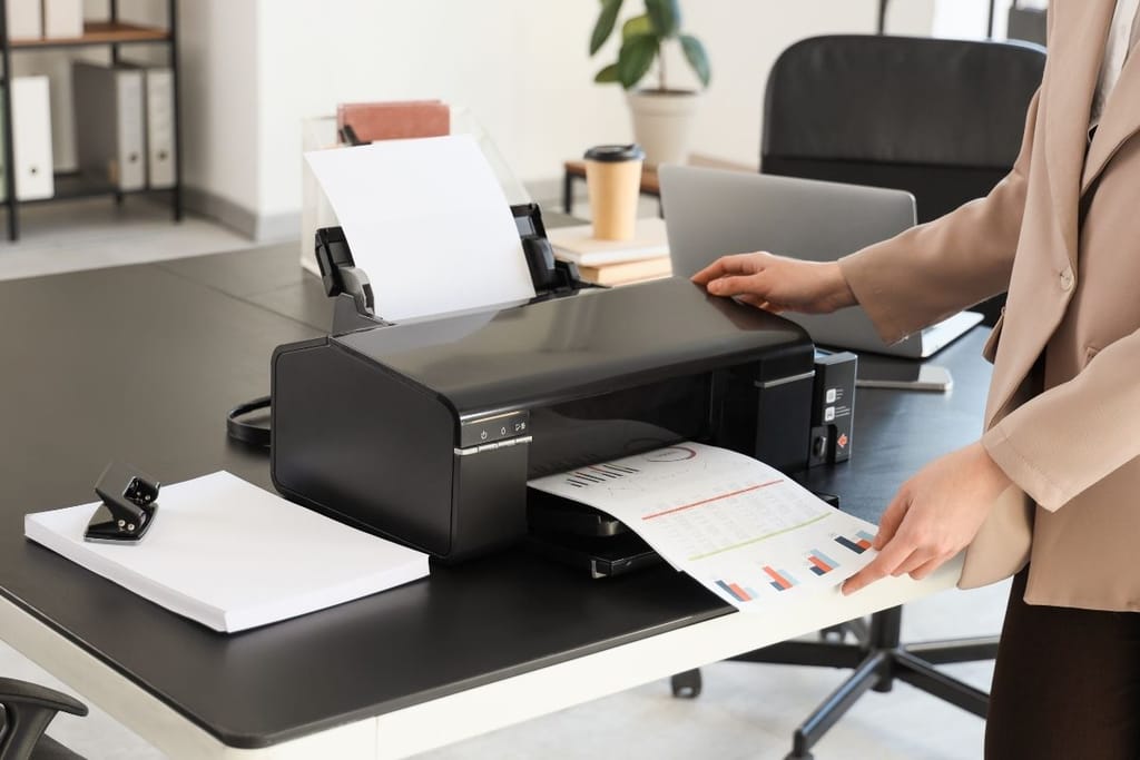 Työntekijä printtaa papereita toimistoympäristössä. 