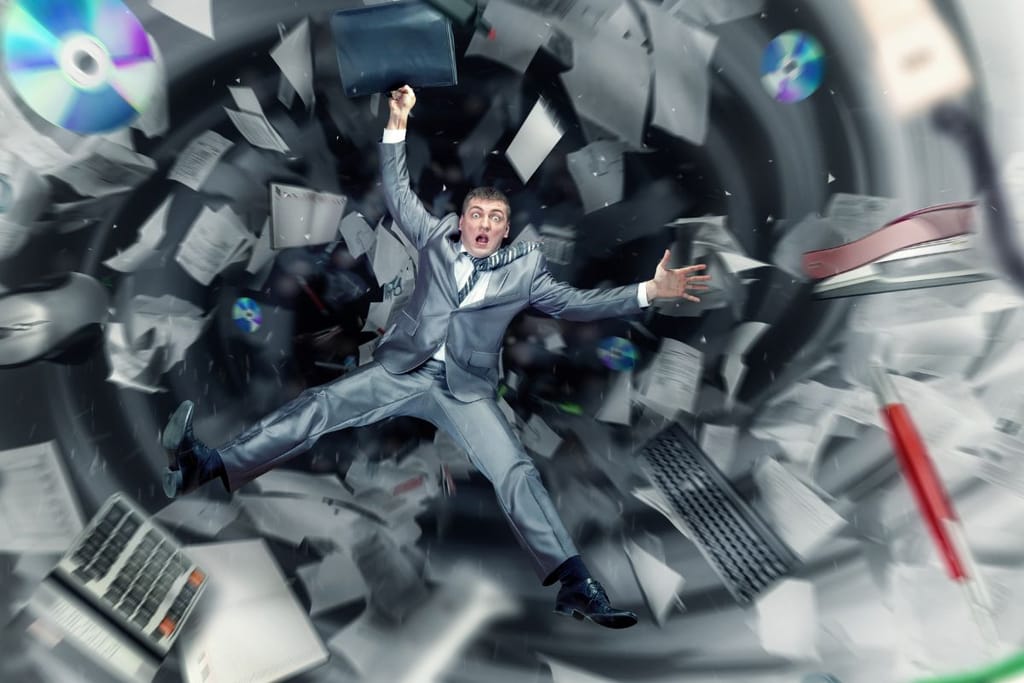 Mies puvussa näyttää putoavan pyörteeseen, jossa paperit, levyt ja toimistoesineet lentävät ympärillä. Ilme ja asento viittaavat kaaokseen ja hallinnan menettämiseen.