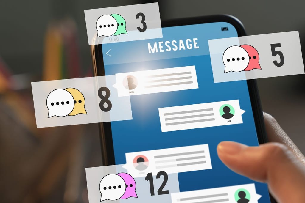 Älypuhelimen näyttö, jossa näkyy viestisovellus ja useita ilmoituskuvakkeita eri väreissä, viitaten aktiiviseen ryhmäkeskusteluun ja uusiin viesteihin.