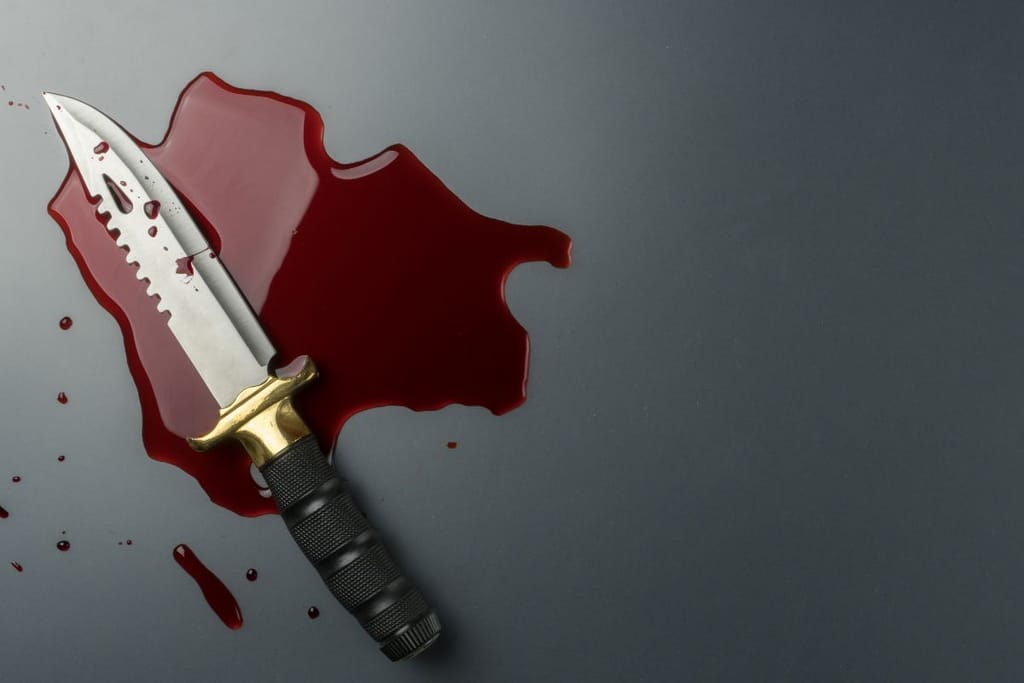 Veitsi pöydällä veriroiskeiden keskellä. 