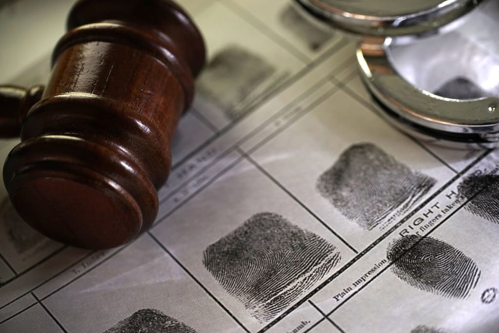 Nuija ja käsiraudat sormenjälkikorttien päällä. 