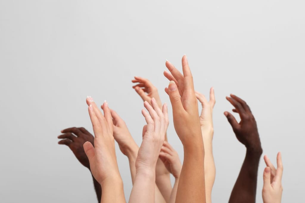 Useita käsiä eri ihonväreissä kohoaa ylöspäin vaaleaa taustaa vasten.