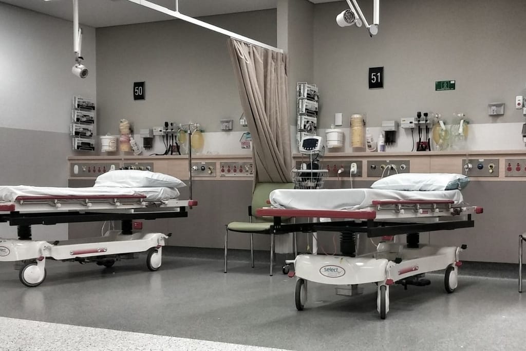 Päivystystila sairaalassa, jossa on sairaalapedit ja ympärillä sairaalatarvikkeita.