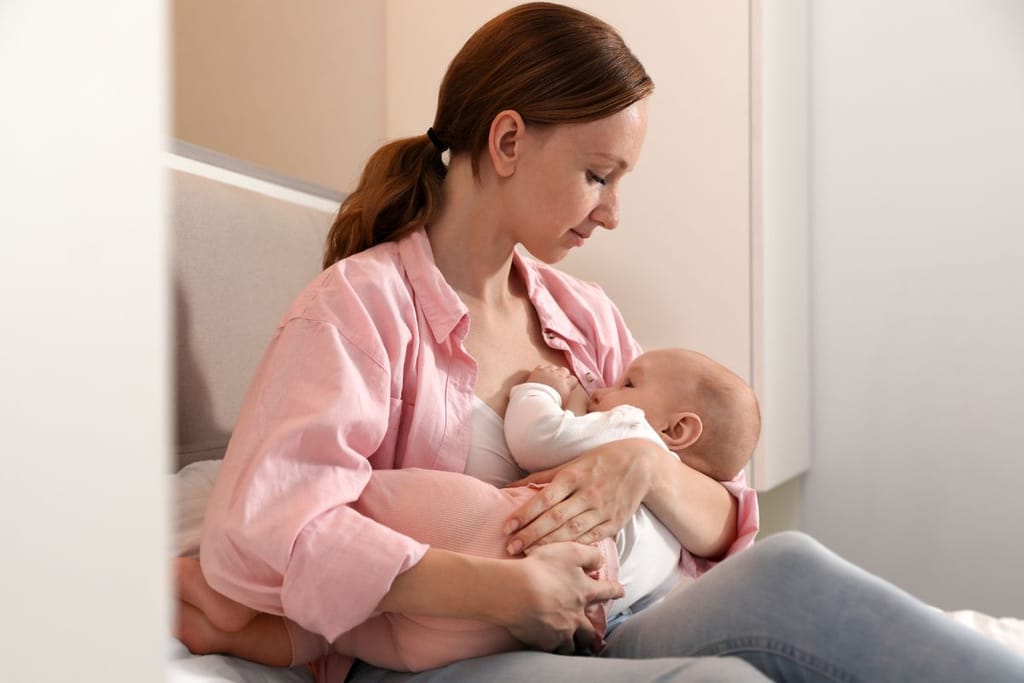 Äiti imettää muutaman viikon ikäistä vauvaansa.