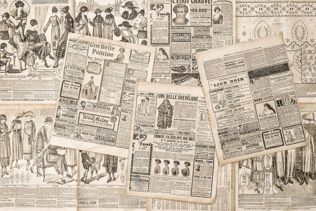 Vanhoja ranskankielisiä sanomalehtiä ja aikakauslehtiä levitettynä päällekkäin, sivuilla piirroskuvia, mainoksia ja tekstiä.