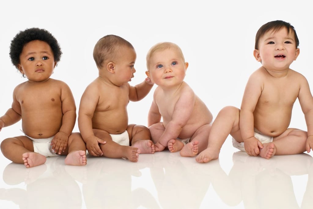 Neljä eri taustoista tulevaa vauvaa istuvat rinnakkain. 