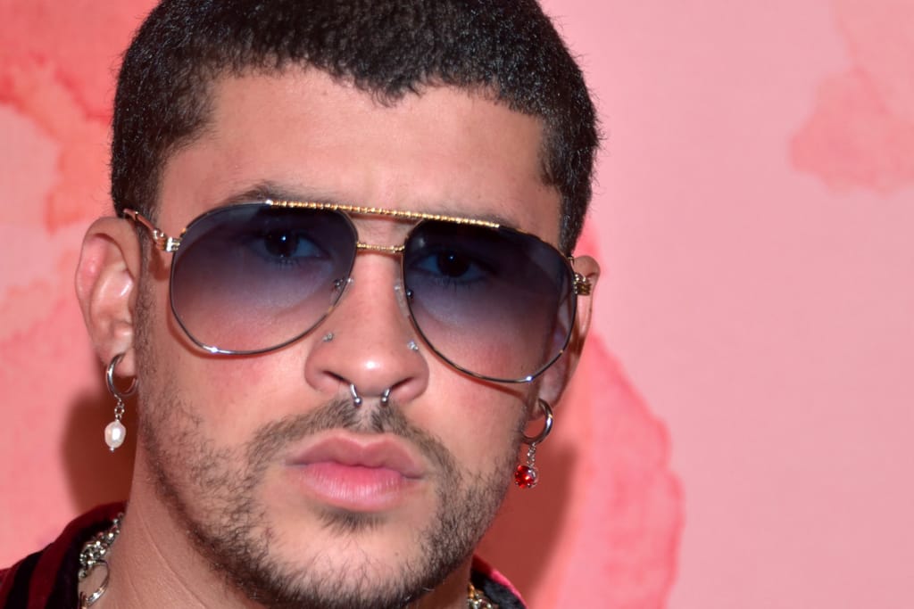 Bad Bunny artisti vaaleanpunaisella taustalla, aurinkolasit päässä