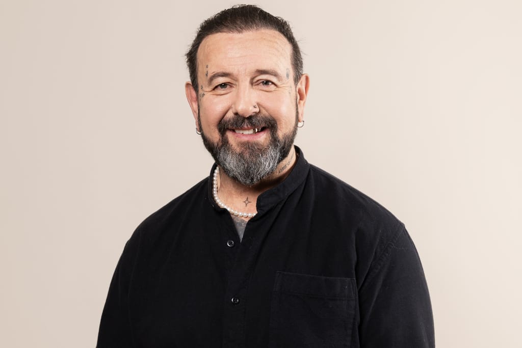 Esko Eerikäinen vaalealla taustalla, musta paita päällä