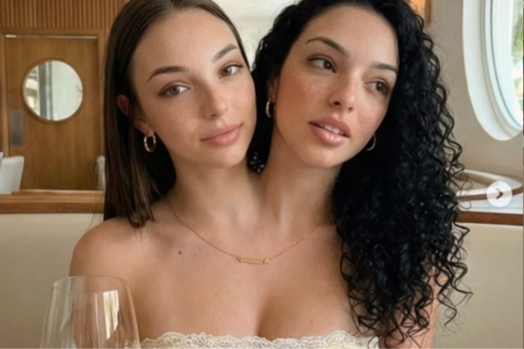 Lähikuva kahdesta yhteen kasvaneiksi esitetystä naisesta sisätilassa, kasvot vierekkäin ja katse kameran ohi.