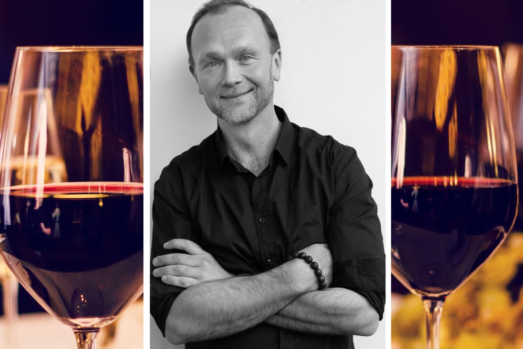 Keskellä mustavalkoinen kuva näyttelijä Jari Virmanista. Taustalla punaviinilaseja.