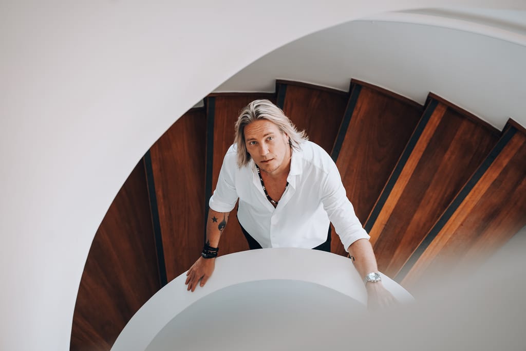 Sami Kuronen seisoo portaissa ja katsoo ylöspäin kameraan.