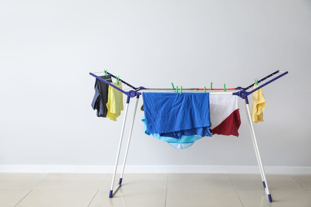 Urheiluvaatteita kuivumassa sisätiloissa kuivaustelineessä.