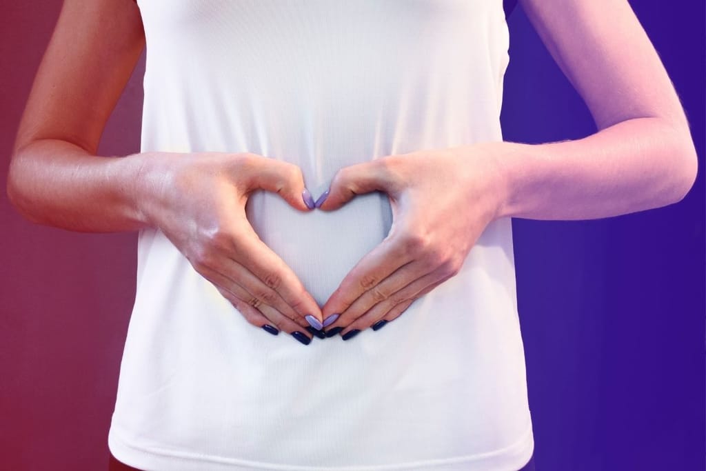Henkilö tekee sydämen muodon vatsan kohdalle, symboloi suoliston hyvinvointia