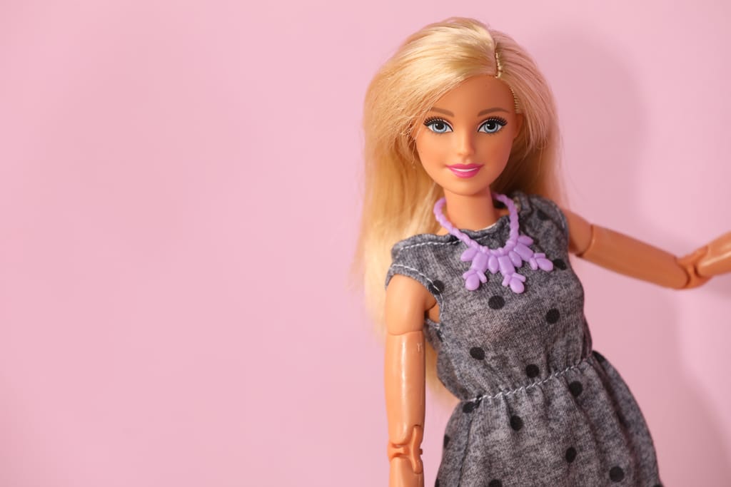 Barbie-nukke vaaleanpunaisella taustalla.